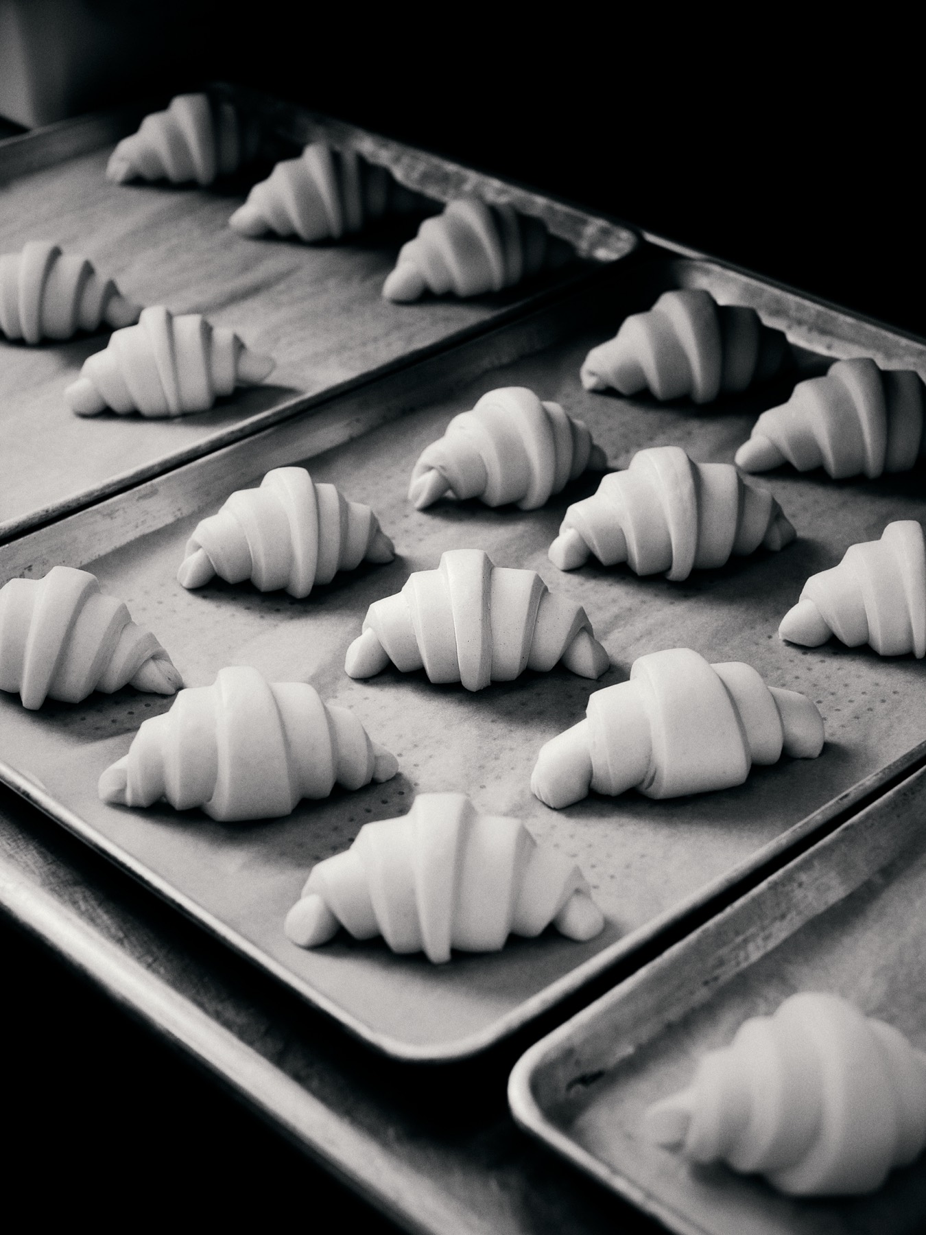 Rows of shaped croissants on a baking sheet